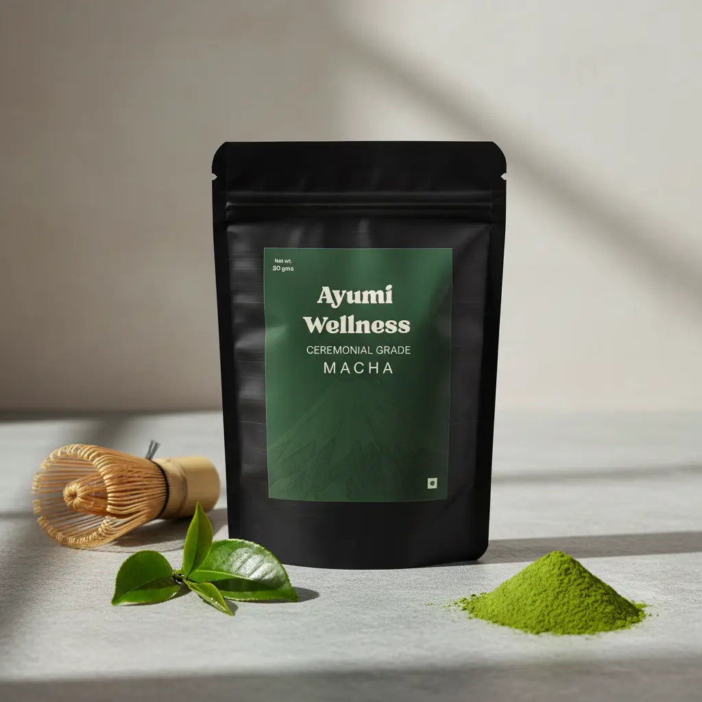 Ayumi Wellness ceremonial grade matcha packaging with green leaves and powder on a neutral background